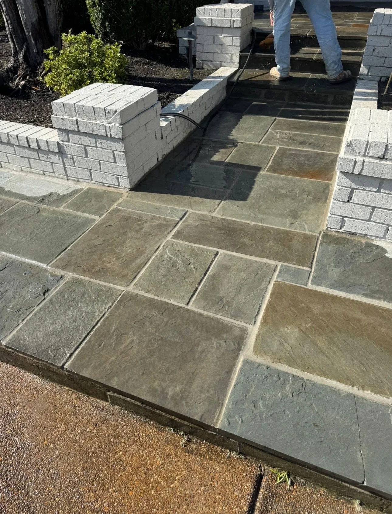 Newly installed slate flagstone patio with concrete block retaining walls and landscape edging